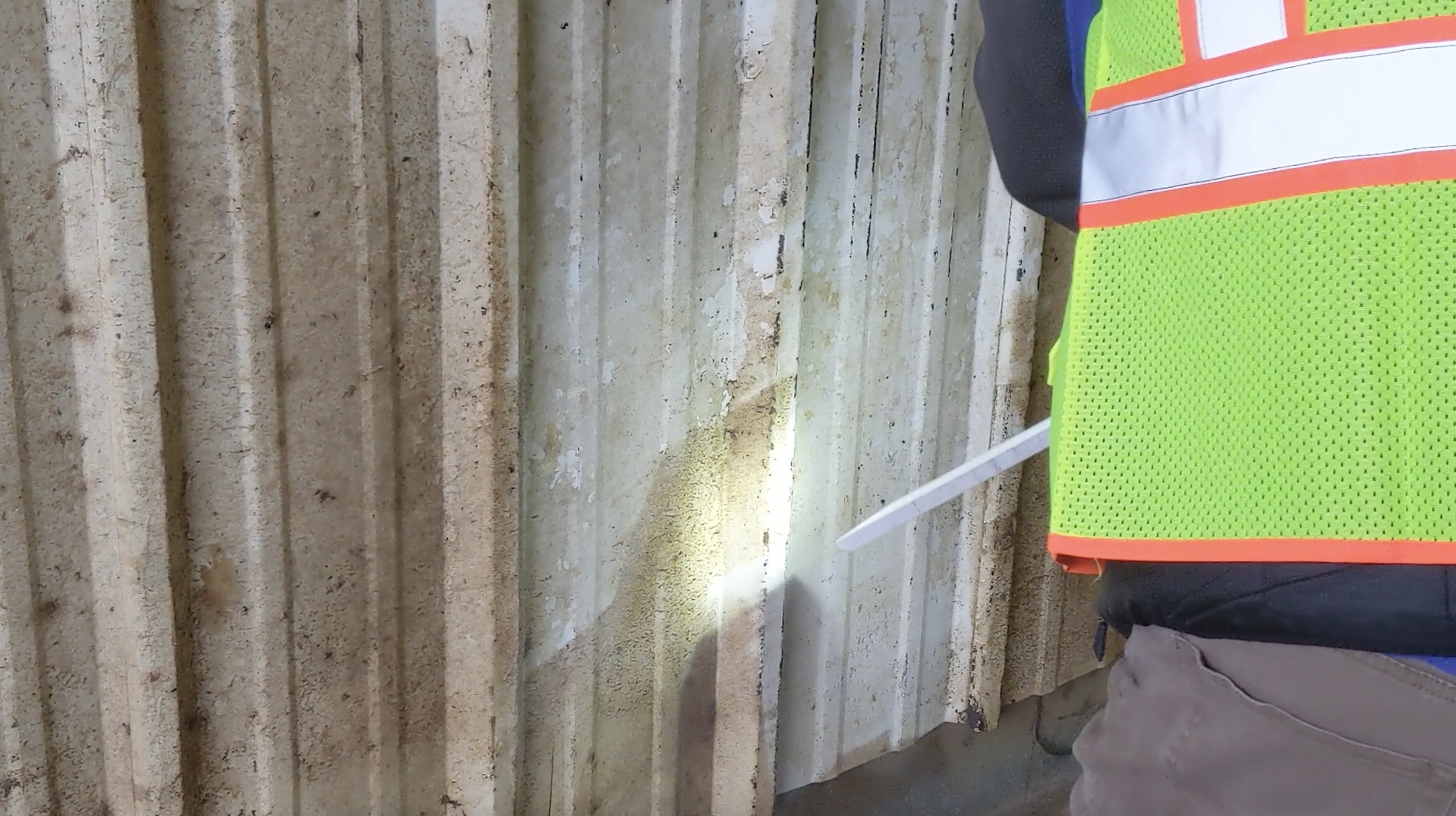 Pracownik w kamizelce czyści metalową elewacje metodą suchego lodu, usuwając uporczywe zabrudzenia. 